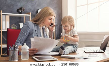 Happy Beautiful Business Mom Talking On Smartphone And Working With Documents In Office While Her Cu