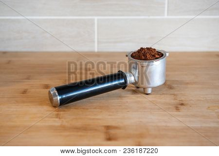 Filter Holder With Ground Coffee On Wooden Table.