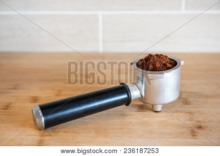 Filter Holder With Ground Coffee On Wooden Table.