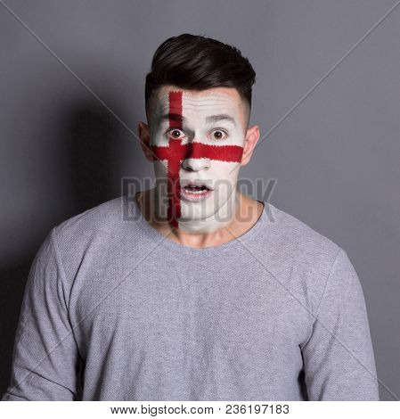 Portrait Of Frustrated Man With The Flag Of England Painted On His Face. Football Or Soccer Team Fan