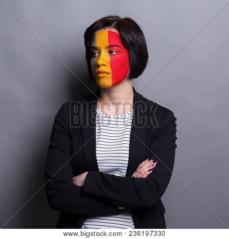 Portrait Of Sad Woman With The Flag Of Belgium Painted On Her Face. Football Or Soccer Team Fan, Spo