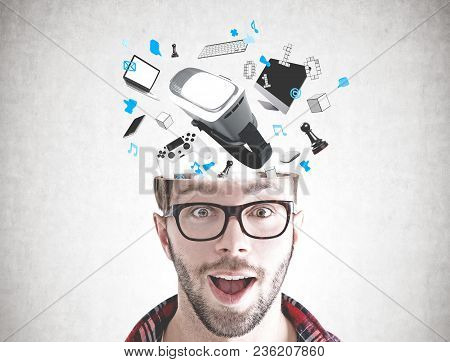 Portrait Of An Astonished Young Man Wearing Glasses And A Checkered Shirt. He Has Gadgets Emegring F