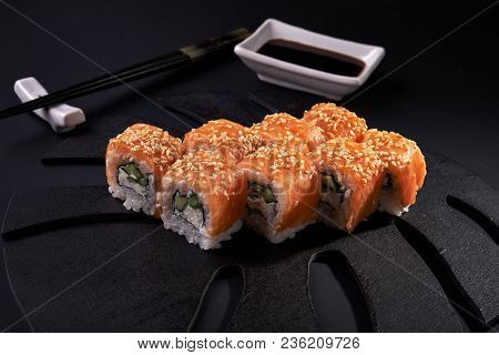 Philadelphia Maki Sushi And Chopstics On Black Background