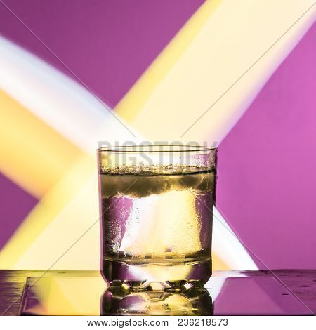 Liquid With Ice In A Glass On A Reflective Surface On A Reddish Background 2018
