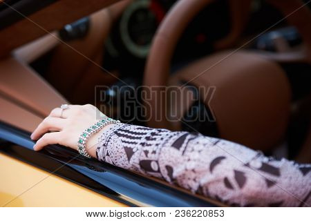 Beautiful Woman With Yellow Sport Car. Young Female Model With Lixury Diamonds Jewerly Sitting In A 