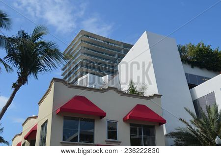 Red Awnings Shading Windows On The Exterior Of A Two Story Sand Colored Apartment Building The The S