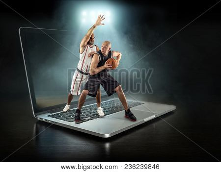 Caucassian Basketball Player in dynamic action with ball in a professional sport game play on the laptop.