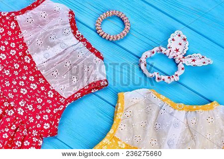 Baby Dresses, Head Wrap, Hair Binder. Close Up Of Baby-girls Sundresses And Hair Accessorries On Blu