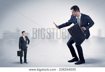 Giant businessman being afraid of small serious executor with suitcase