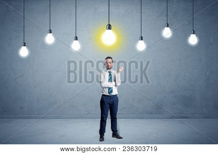 Handsome businessman in an empty space with bulbs above and uninspired face