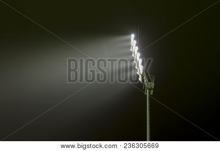 Close View Of A Sports Stadium Flood Light Lighting The Sky On A Dark Night