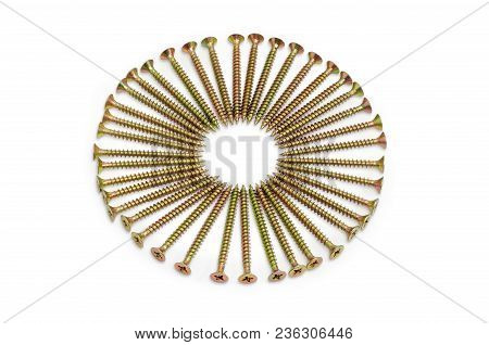 Long Zinc Plated Chipboard Screws With Countersunk Heads, Laid Out In A Circle Closeup On A White Ba