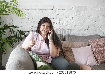 People, Lifestyle And Modern Technologies Concept. Picture Of Gorgeous Chubby Young Woman Talking On