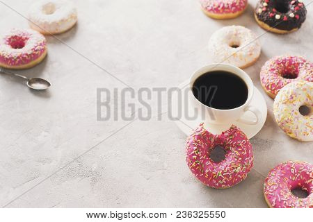 Sone Pink And White Donuts With Cup Of Coffee Over White Stone Texture, Top View, Copy Space