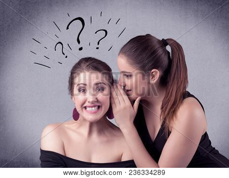 A teenager girl looking confused with drawn question marks above the head, while a girlfriend whispers something in her ear concept.