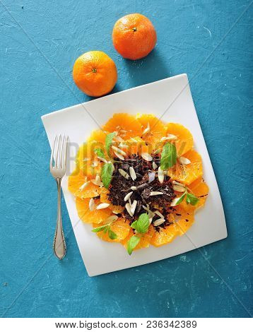 Slices Of Oranges Marinated In Orange Liqueur Topped With Dark Chocolate. Almond And Mint.