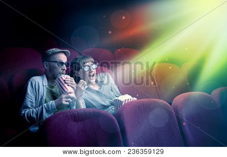 Teenager couple cuddling and watching the climax part of the movie