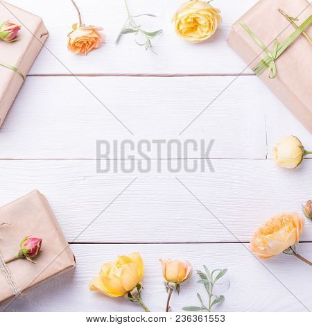 Flowers Composition. Gifts And Rose Flowers On White Wooden Table. Women Day. Flat Lay, Top View
