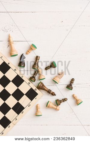 Wooden Chess Figures And Part Of A Chess Board On White Table Background. Top View.