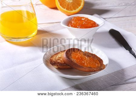Morning Breakfast Set With Orange Jam On Bread Toast And Juice In Glass
