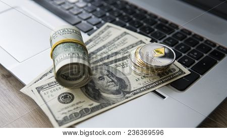 Ethereum Cryptocurrency On Top Of 100 Dollar Biils On A Laptop. Profit From Mining Crypto Currencies