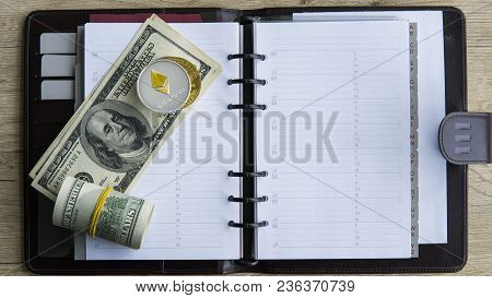 Ethereum Crypto Currency On Top Of 100 Dollar Biils On Notepad. Profit From Mining Crypto Currencies
