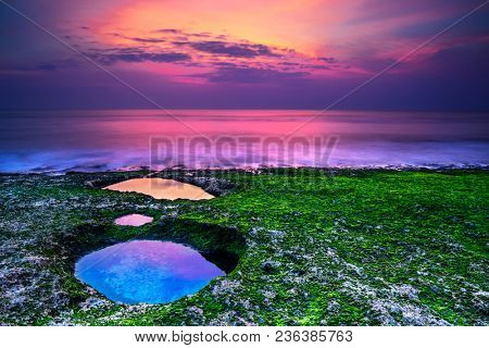 Beautiful landscape of an amazing purple sunset over the sea, majestic view of Padang Padang beach in the evening, Bali, Indonesia