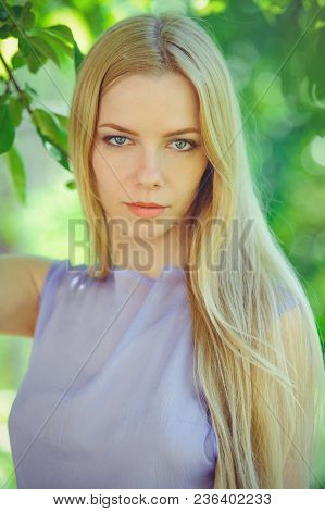 Attractive Modest Young Girl With Blond Dren Hair And Natural Make-up In Purple Dress Outdoors, Tend