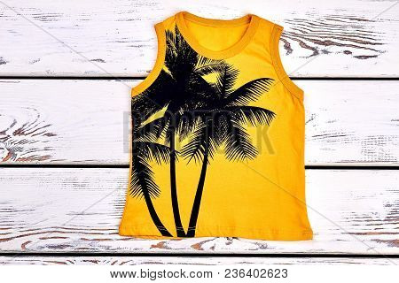 Kids Yellow Printed T-shirt. Childrens Sleeveless T-shirt With A Pattern Of Palm Trree On White Wood