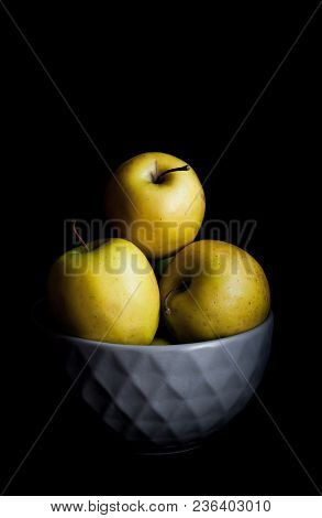 Bowl Of Yellow Apples. On Black Background. A