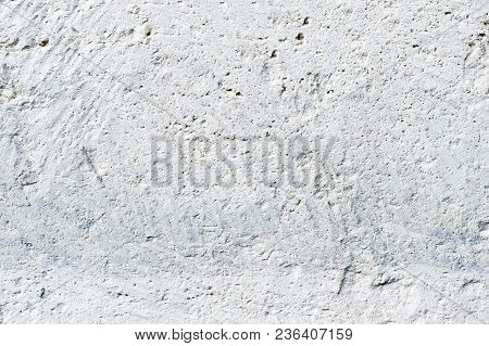 Close-up Deep Texture Of White-painted Porous Stone On The Facade Of The Building. Stoned Wall Backg