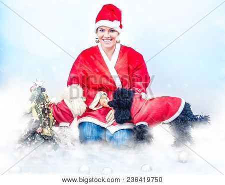 Cheerful Young Woman In Christmas Outfit Accompanied By Two Sweet Poodles