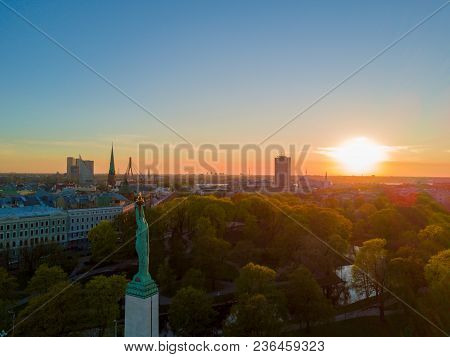 Amazing Aerial Sunset View Over Riga City In Latvia. Statue Of Liberty In The Middle Of The City - M