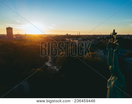 Beautiful Sunset View Over Riga By The Statue Of Liberty - Milda In Latvia. The Monument Of Freedom.