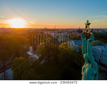 Beautiful Sunset View Over Riga By The Statue Of Liberty - Milda In Latvia. The Monument Of Freedom.