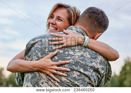 Happy Woman Hugging His Husband Came Back From Army. Smiling Cheerful Caucasian Girlfriend Embracing
