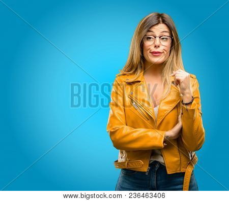 Beautiful young woman making funny face fooling, blue background