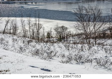 Partially Frozen Lake Manistee Sits Below A Bluff
