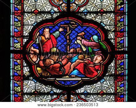 PARIS, FRANCE - JANUARY 05, 2018: Exposition of the brass serpent in the desert, prefiguration of the Crucifixion, stained glass window in the Basilica of Saint Clotilde in Paris, France.