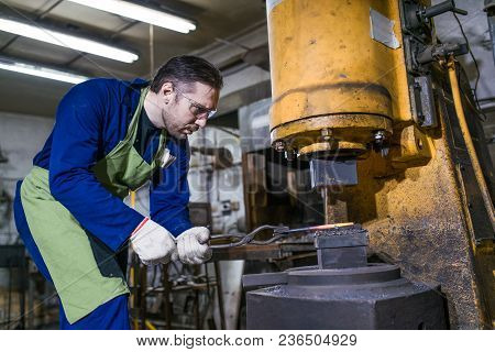 A Brutal Man Works In A Workshop, Forges Iron.