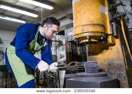 The Smith Works With An Electric Hammer.