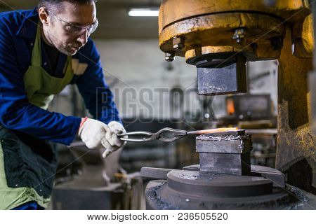 The Smith Works With An Electric Hammer.