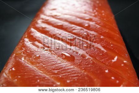 Trout Slice With Oil Drops On A Dark Blurry Background Close-up