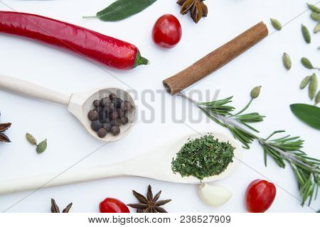 Cooking Hot Spicy Food Concept. Dry Spices And Herbs In Wooden Spoons And Chili Pepper, White Backgr