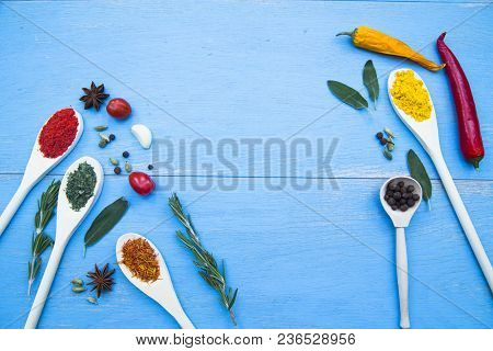 Cooking Hot Spicy Food Concept. Dry Spices And Herbs In Wooden Spoons, Fresh Herbs, Chili Peppers An