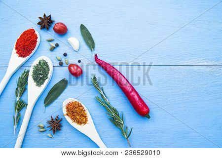 Cooking Hot Spicy Food Concept. Dry Spices And Herbs In Wooden Spoons, Fresh Herbs, Chili Peppers An