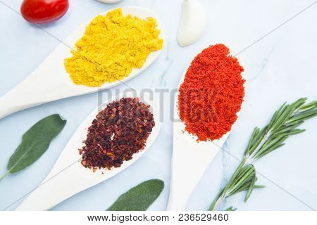 Cooking Hot Spicy Food Concept. Dry Spices And Herbs In Wooden Spoons White Marble Background, Top V