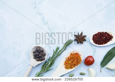Cooking Hot Spicy Food Concept. Dry Spices And Herbs In Wooden Spoons, Fresh Herbs And Beans, White 