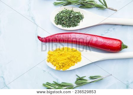 Cooking Hot Spicy Food Concept. Dry Spices And Herbs In Wooden Spoons, Fresh Herbs And Chili Peppers