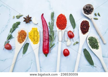 Cooking Hot Spicy Food Concept. Dry Spices And Herbs In Wooden Spoons, Fresh Herbs, Chili Peppers An